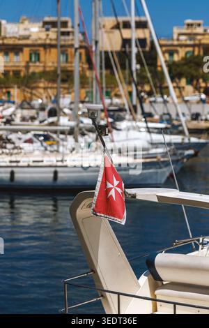 Eine Reihe traditioneller maltesischer Fischerboote, bekannt als Luzzu, in leuchtenden Primärfarben gemalt. Die Boote liegen in den ruhigen Gewässern von Marsaxlokk h Stockfoto