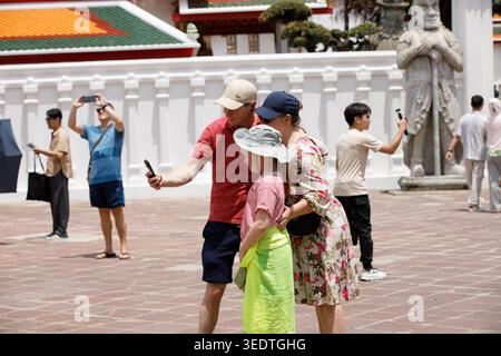 BANGKOK, THAILAND-29. März 2026: Touristenfamilie macht Selfie im thailändischen Tempel, Reise-Lebensstil und digitales Verhalten, Wat Pho. Stockfoto