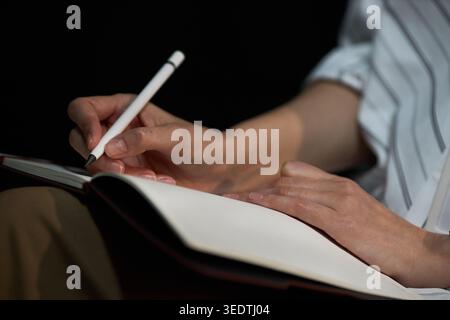 Erwachsene Frau schreibt in Notebook für Planung und Produktivität Stockfoto