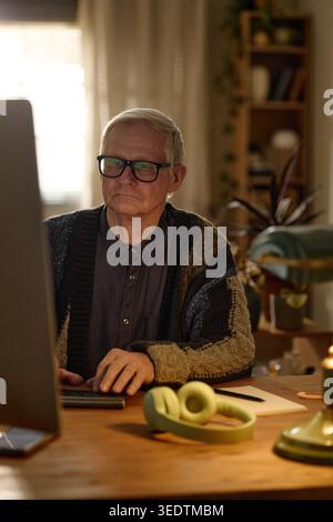 Senior-Mann, der im Home Office am Desktop-Computer arbeitet Stockfoto