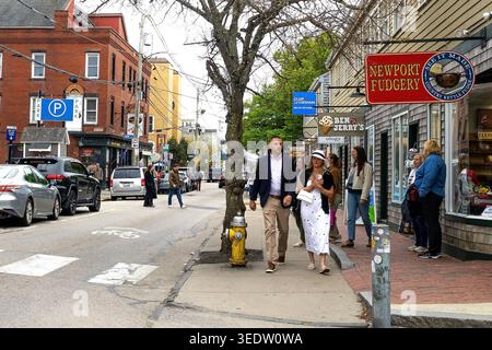 Downtown Newport, Rhode Island, stilvolle Mann und Frau, die an Newport Fudgery auf der Themse Street, Hauptstraße oder Hauptstraße des Küstendorfes vorbeilaufen Stockfoto