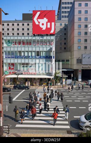 Die Menschen überqueren die Straße an der Fußgängerzone in Umeda, einem großen Handels-, Geschäfts- und Einkaufsviertel in Osaka, Japan. Stockfoto