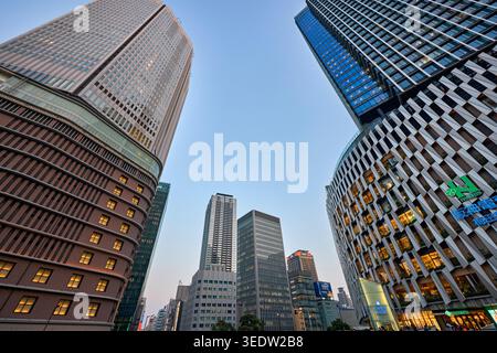 Moderne Gebäude in Umeda, einem großen Handels-, Geschäfts- und Einkaufsviertel in Osaka, Japan, beleuchtet bei Dämmerung. Stockfoto