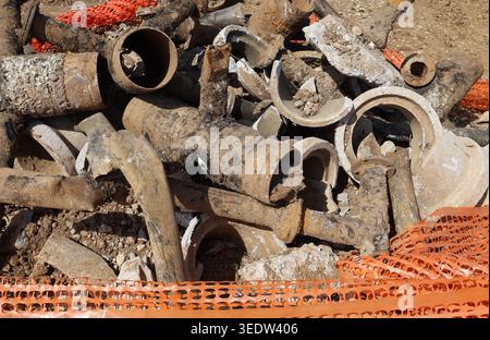 Alte, verrostete Gusseisen-Wasserleitungen wurden von einer Baustelle entfernt. Die Rohre von Sanitäranlagen weisen Oxidation und Sedimentrost auf. Stockfoto