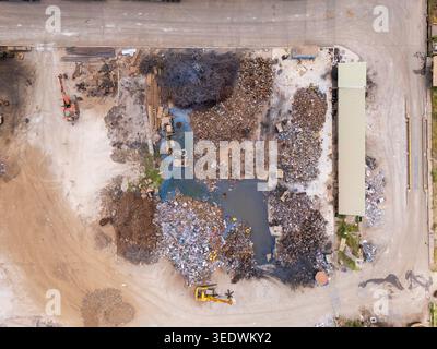 Hochwinkelansicht von Schrottpfählen und schweren Maschinen in einem Recyclingzentrum in Ho Chi Minh City, Vietnam Stockfoto