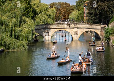 Menschen und Touristen genießen das Klettern auf dem Fluss Cam unter einer Steinbrücke und Weinweiden, Cambridge, England Stockfoto