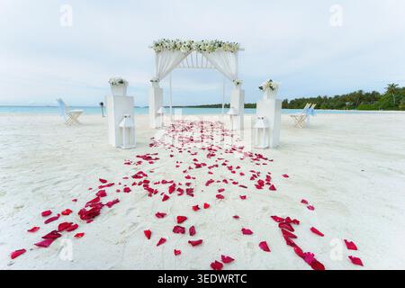Wunderschöner romantischer festlicher Ort am Strand mit blauem Meer oder Meer im Hintergrund. Blumenrosendekoration für die Hochzeitszeremonie im Dream isl Stockfoto