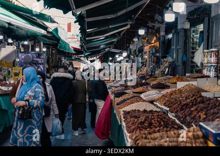 Die Leute stöbern an Ständen mit getrockneten Früchten, Datteln und Nüssen auf einem belebten traditionellen Markt in Tetouan, Marokko Stockfoto