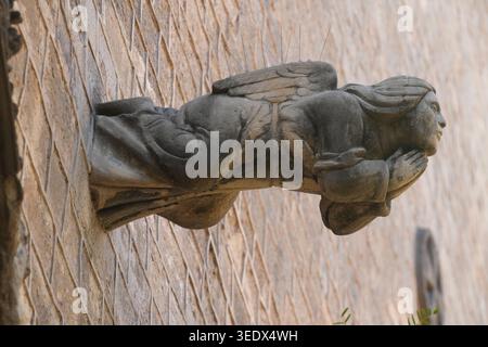 Architektonische Steinschnitzerei einer Engelsfigur, oft als Groteske oder Gargoyle bezeichnet Stockfoto