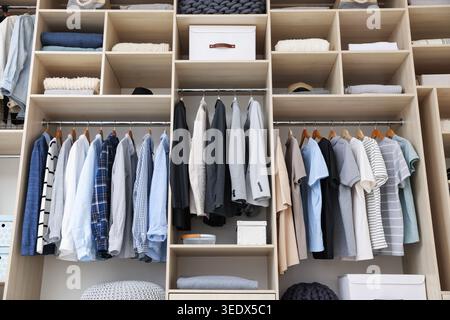 Kleiderschrank mit verschiedenen stilvollen Kleidungsstücken, Accessoires und Haushaltsgegenständen im Innenbereich, geringer Blickwinkel Stockfoto
