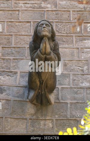 Architektonische Steinschnitzerei einer Engelsfigur, oft als Groteske oder Gargoyle bezeichnet Stockfoto