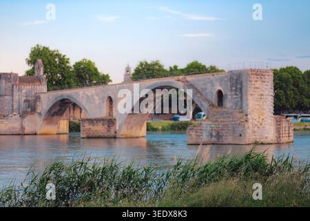 Avignon, Frankreich: Ruinen der Brücke Saint Benezet über den Fluss Rhone unter klarem Himmel. Berühmte mittelalterliche Steinbögen von Pont d'Avignon. Hintergrund für Sommerreisen Stockfoto