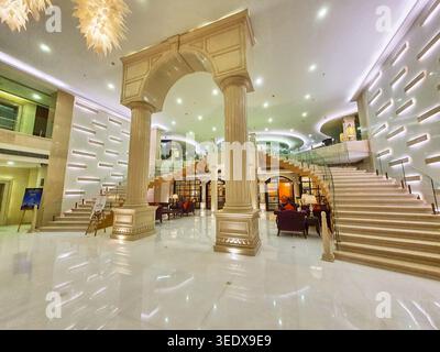 Ein luxuriöses Hotellobby-Interieur mit grandioser Marmorarchitektur und großen Säulen und Bögen im römischen Stil. Der Raum umfasst ein elegantes Stockfoto