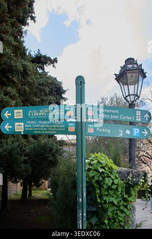 Valldemossa, Spanien - 6. Mai 2026: Ein grüner Wegweiser in Valldemossa weist Besucher in Richtung Chopin Museum und Real Cartuja unter einem b Stockfoto
