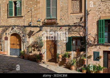 Valldemossa, Spanien - 6. Mai 2026: Malerische Steinfassade traditioneller mediterraner Häuser mit Blumentöpfen und Kletterpflanzen entlang einer Stockfoto