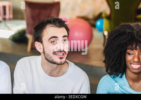 Junger Mann, der sich mit einer Gruppe von Freunden unterhalten hat Stockfoto