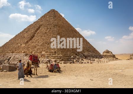 Kairo, Ägypten, 25.07.21. Pyramide von Menkaure in Ägypten, Außenansicht mit Kamelen vor der Pyramide und Kamelführer. Stockfoto
