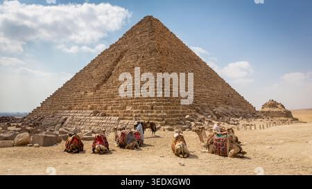 Kairo, Ägypten, 25.07.21. Pyramide von Menkaure in Ägypten, Außenansicht mit Kamelen vor der Tür und Kamelführer herum. Stockfoto