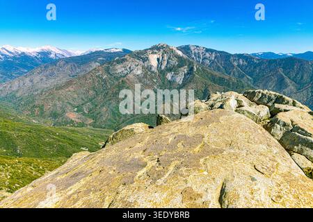 Atemberaubender panoramablick von einem Granitgipfel mit Blick auf geschichtete Bergkämme, bewaldete Täler und entfernte schneebedeckte Gipfel im Sequoia NP Stockfoto