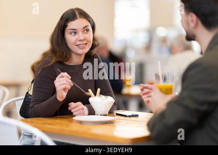 Junge Paare sitzen im Café und genießen Dessert mit Getränken Stockfoto