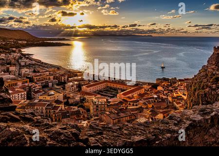 Panorama-Aussicht bei Sonnenuntergang über Cefalù von La Rocca mit Bucht, Strand, alter Stadt und glühendem Mittelmeerlicht - Cefalu, Sizilien, Italien Stockfoto