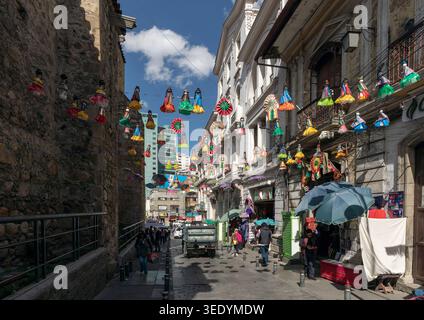 Farbenfrohe Cholita-Puppen-Dekorationen hängen über Sagarnaga, einer Souvenirladenstraße in der Innenstadt von La Paz, Bolivien Stockfoto