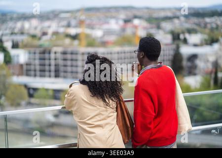 afroamerikanische Touristen besuchen Sehenswürdigkeiten in der neuen Stadt, verheiratete Paare genießen die Aussicht auf Wahrzeichen. Stockfoto
