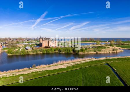 Die atemberaubende Landschaft der niederländischen Landschaft in der Nähe von Muiden, mit dem mittelalterlichen Muiderslot Castle, das über lebendige grüne Polderfelder sichtbar ist. Die Ve Stockfoto