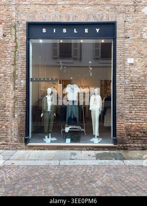 Cremona, Italien, 9. April 2026 Sisley-Schaufensterfront mit großem Glasfenster, die aktuelle Modekollektion auf Schaufensterpuppen in der urbanen Backsteinstraße faca zeigt Stockfoto