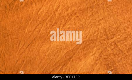 Nahbeschaffenheit des zerknitterten Senfgelbbwoll-Stoffhintergrunds mit natürlichem Licht und weichen Schatten für modisches Textildesign. Stockfoto