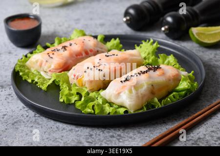 Asiatische Lebensmittel Frühlingsrollen mit Garnelen, Gemüse in Reispapier auf grauem Hintergrund gewickelt. Nahaufnahme. Vietnamesische Küche. Stockfoto