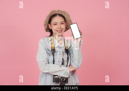 Asiatische Reisende zeigt Smartphone mit leerem Bildschirm für Reise-App Stockfoto