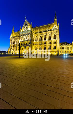 Das Parlamentsgebäude in Budapest wird bei Nacht beleuchtet und zeigt seine beeindruckende Architektur vor dem klaren Himmel. Stockfoto