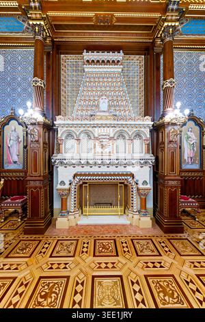 Besucher bewundern die detaillierte Architektur des Stephanssaals in Budapest, Ungarn, mit Schwerpunkt auf dem Kamin und kunstvollen Designelementen. Stockfoto