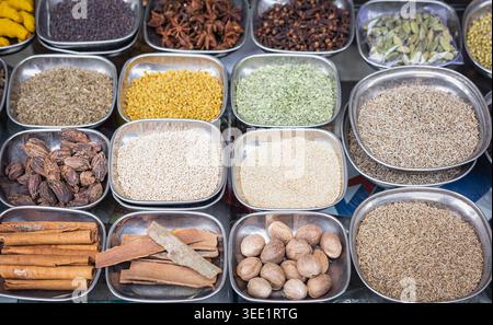 Verschiedene Gewürze, Gewürze in den Metallplatten. Auswahl an Gewürzen und Samen, Draufsicht. Kreuzkümmel, Kardamom, Sesamsamen, muskatnuss, Fenchel, m Stockfoto