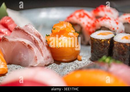 Blick auf eine frische Sushi- und Sashimi-Platte mit Lachs, weißem Fisch und Maki-Brötchen mit Reh. Stockfoto