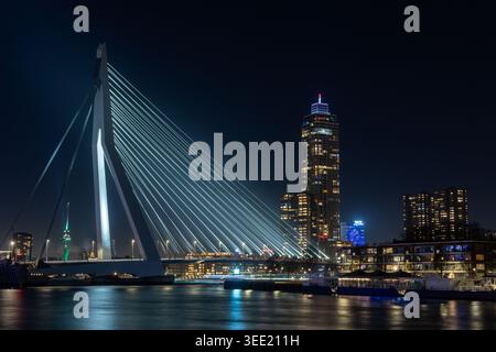 Blick auf die beleuchtete Erasmusbrug und die Skyline der Stadt bei Nacht mit dem Wolkenkratzer de Zalmhaven, der sich auf dem Wasser in Rotterdam, Zuid-Holland, Net reflektiert Stockfoto