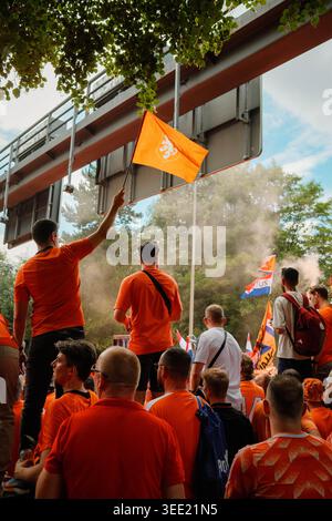 Die niederländischen Fans in orangen Hemden schwingen während des fanmarsches in Dortmund vor der UEFA Euro niederländische Fahnen und eine orangene Löwenflagge Stockfoto