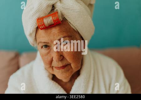 Seniorin mit Haaren, die nach dem Duschen in ein Handtuch gewickelt sind. Stockfoto