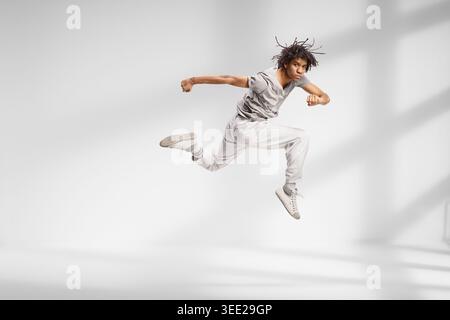 afroamerikaner, der einen Tanzsprung in einem Studio macht Stockfoto