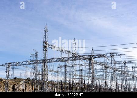 Elektrisches Unterwerk mit zahlreichen Metalltürmen und Hochspannungsleitungen, Teil des Energieübertragungsnetzes Stockfoto