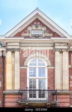 Nahaufnahme der Flavelle House-Fassade mit Bogenfenster, gemauerter Fassade, klassischen Säulen und dekorativem 1902-Giebel. Stockfoto