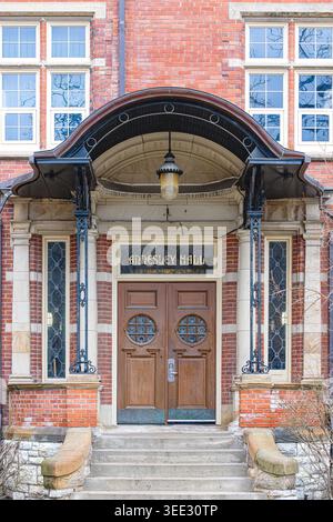 Vordereingang der Annesley Hall mit gewölbtem Vordach, Holztüren, Buntglaspaneelen und historischer Ziegelfassade. Stockfoto