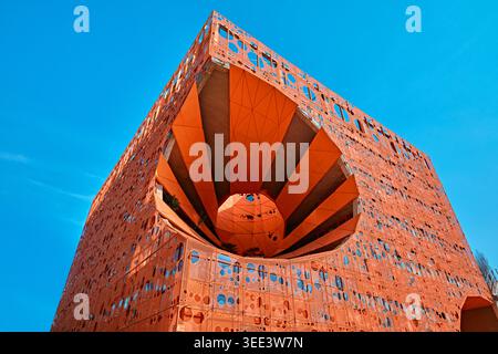 Lyon, Frankreich - 19. März 2026: Flacher Blick auf die leuchtend orange perforierte Fassade und das kreisförmige Leere des Le Cube Orange Gebäudes in Lyon Stockfoto
