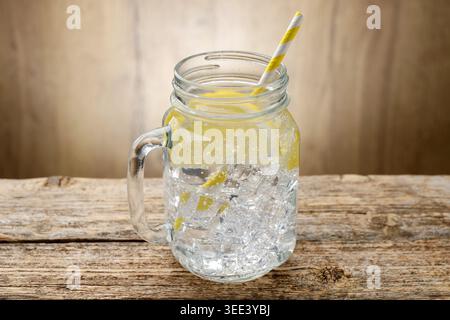 Erfrischendes Wasser mit Zitrone in Glas-einmachglas auf Holztisch, Nahaufnahme Stockfoto