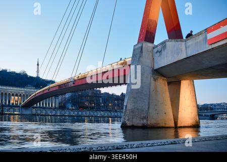 Lyon, Frankreich - 19. März 2026: Blick auf die rote Brücke Passerelle du Palais de Justice über den Saone bei Dämmerung mit Stadtlichtern Stockfoto