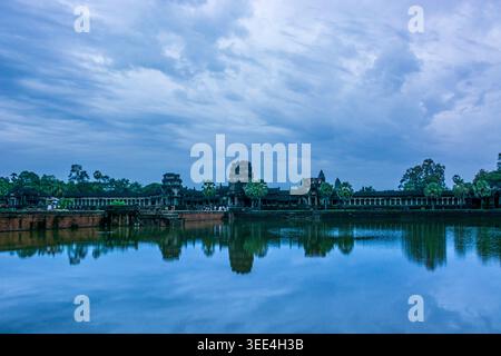 Ein eindrucksvoller Sonnenaufgang über Kambodschas alten Tempel Angkor Wat. Die ikonischen Khmer-Türme spiegeln sich perfekt in den ruhigen Wassergräben und schaffen eine Symme Stockfoto