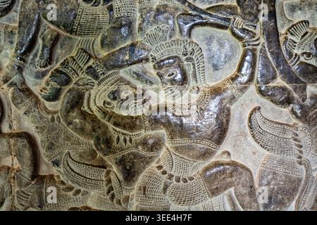 Detailliertes Flachrelief in Angkor Wat, Kambodscha, das die epische Schlacht von Lanka aus dem Ramayana darstellt. Die Sandsteinschnitzerei fängt Hanumans Affenarm ein Stockfoto