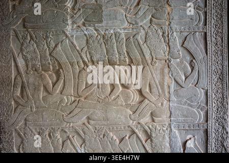 Nahaufnahme eines Sandsteinreliefs im Angkor Wat Tempel, Kambodscha. Die Schnitzerei zeigt eine Reihe sitzender Himmelsfiguren mit komplizierten Kopfschmuck ho Stockfoto