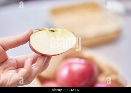 Lebendige Fuji-Äpfel, ganz und in Scheiben geschnitten, zeigen knackiges, saftiges Fleisch. Wird in einem Korb und auf einer grauen Oberfläche angezeigt, wodurch die Qualität der Beogeum-Früchte hervorgehoben wird. Stockfoto